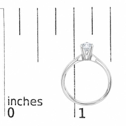 White metal ring with a round white gemstone in a four-prong setting, shown on a scale, side angle.