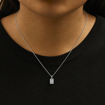 Close-up front view of a white necklace with an emerald-shaped white gemstone pendant in a 4-prong setting, shown worn on a model.