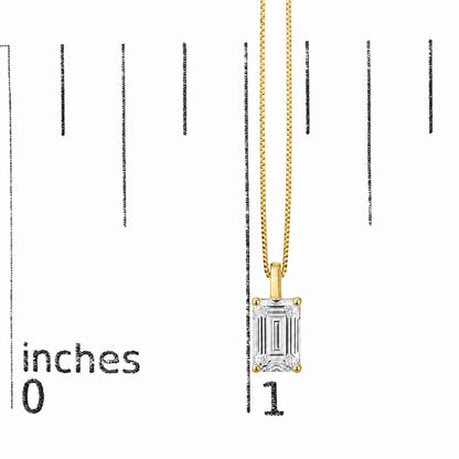 Close-up front view of a yellow metal necklace with a rectangular emerald-cut white gemstone set in a four-prong setting, shown on a scale.
