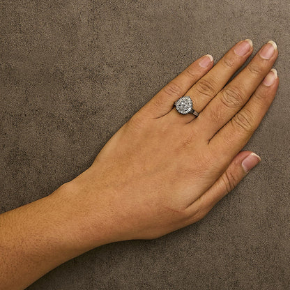 White metal ring with round and baguette shaped white gemstones in prong and channel settings, worn on a model's hand, shown from above angle.