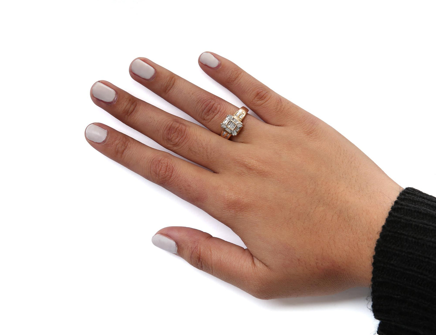 Yellow metal ring with white baguette and princess shaped gemstones in channel and bezel settings, worn on a model's hand shown from the top angle.