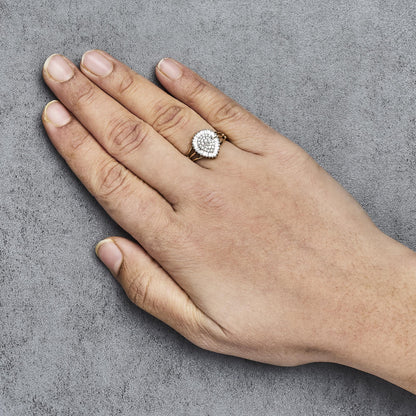 Yellow metal ring with pear-shaped cluster of white round gemstones in prong setting, surrounded by white baguette gemstones in channel setting, shown on a model's hand from top angle.