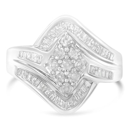 Close-up front view of a white metal ring featuring a cluster of round white gemstones in prong settings at the center, surrounded by rows of baguette white gemstones in channel settings along the band.