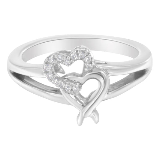 White metal ring with two interlocking heart shapes, one heart set with round white gemstones, shown from a front angle.