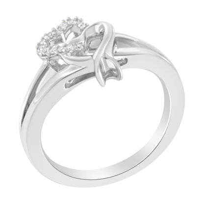 White metal ring with two heart-shaped designs, one outlined with small white gemstones in prong settings, shown at a slight angle.