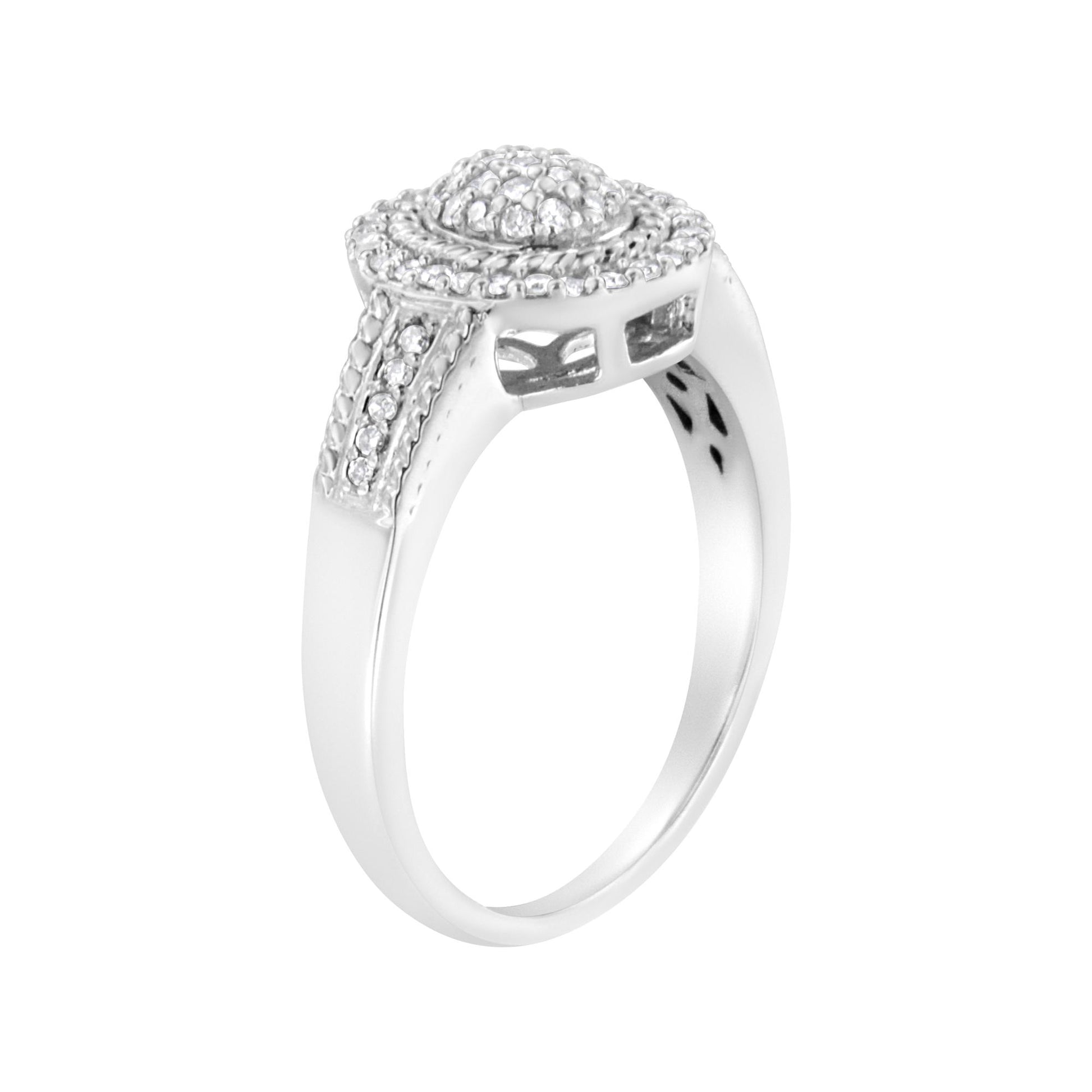 Side angled view of a white metal ring with round white gemstones in a pave setting on the top and along the shoulders.