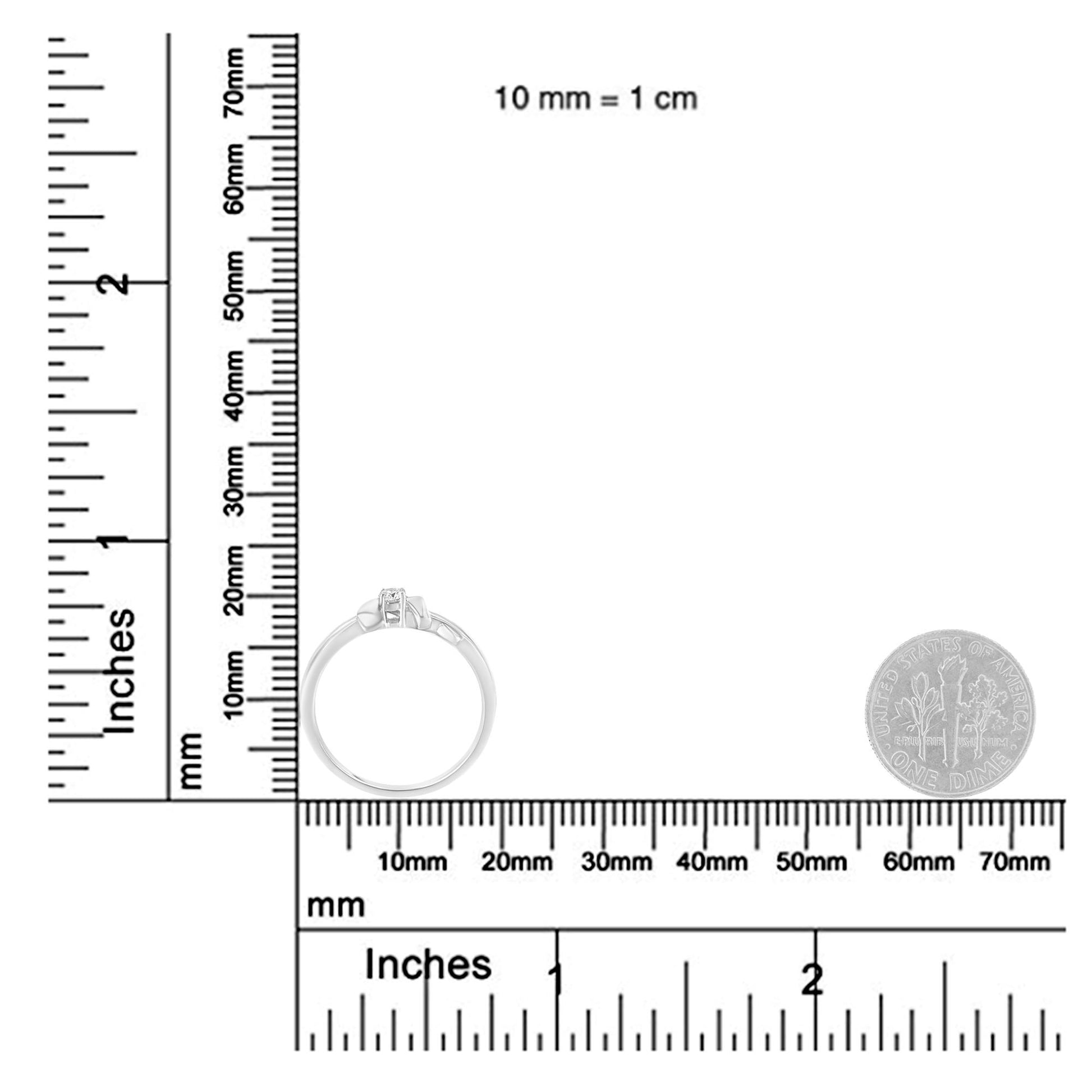 White metal ring with single round white gemstone in prong setting, shown from side angle on a ruler and scale for size reference.