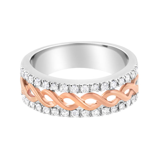 Close-up front angle of a white and rose metal ring with a twisted rose metal band in the center surrounded by two rows of round white gemstones in prong settings.
