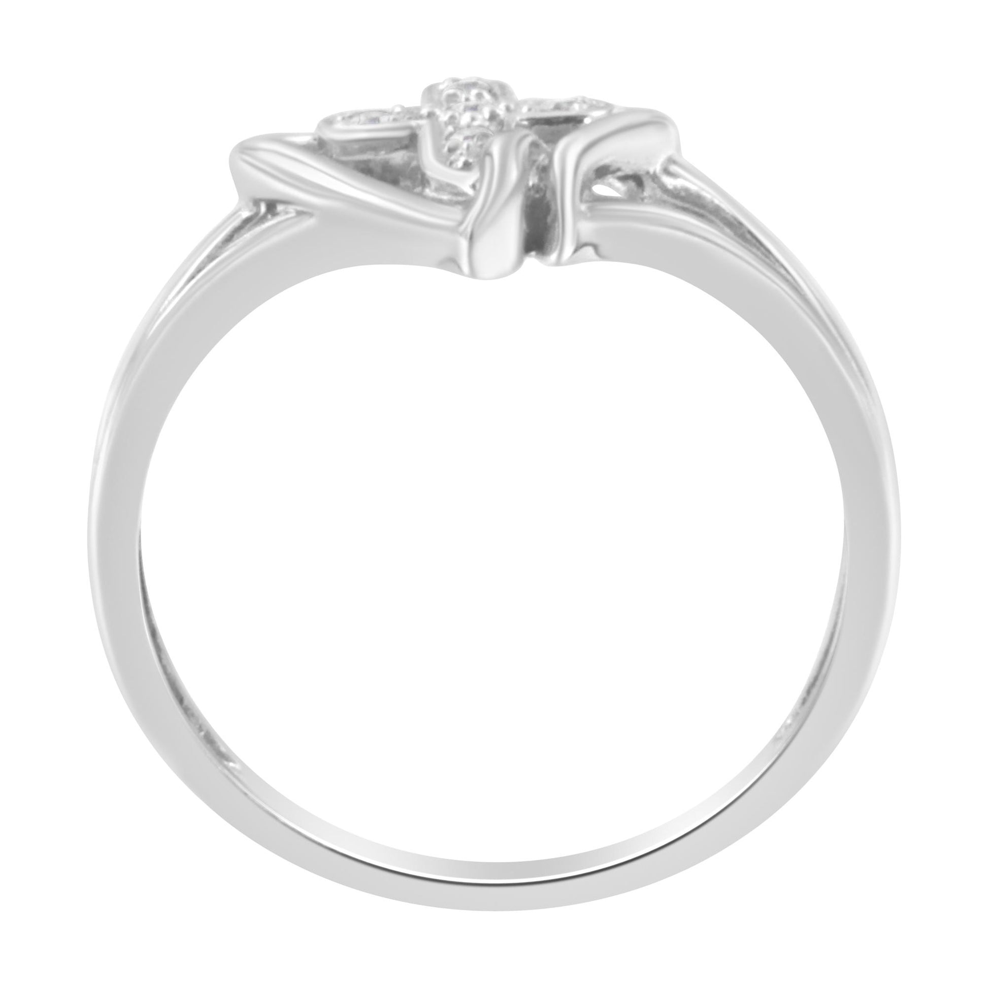 White metal ring viewed from the side, featuring five small round white gemstones in prong settings at the top.