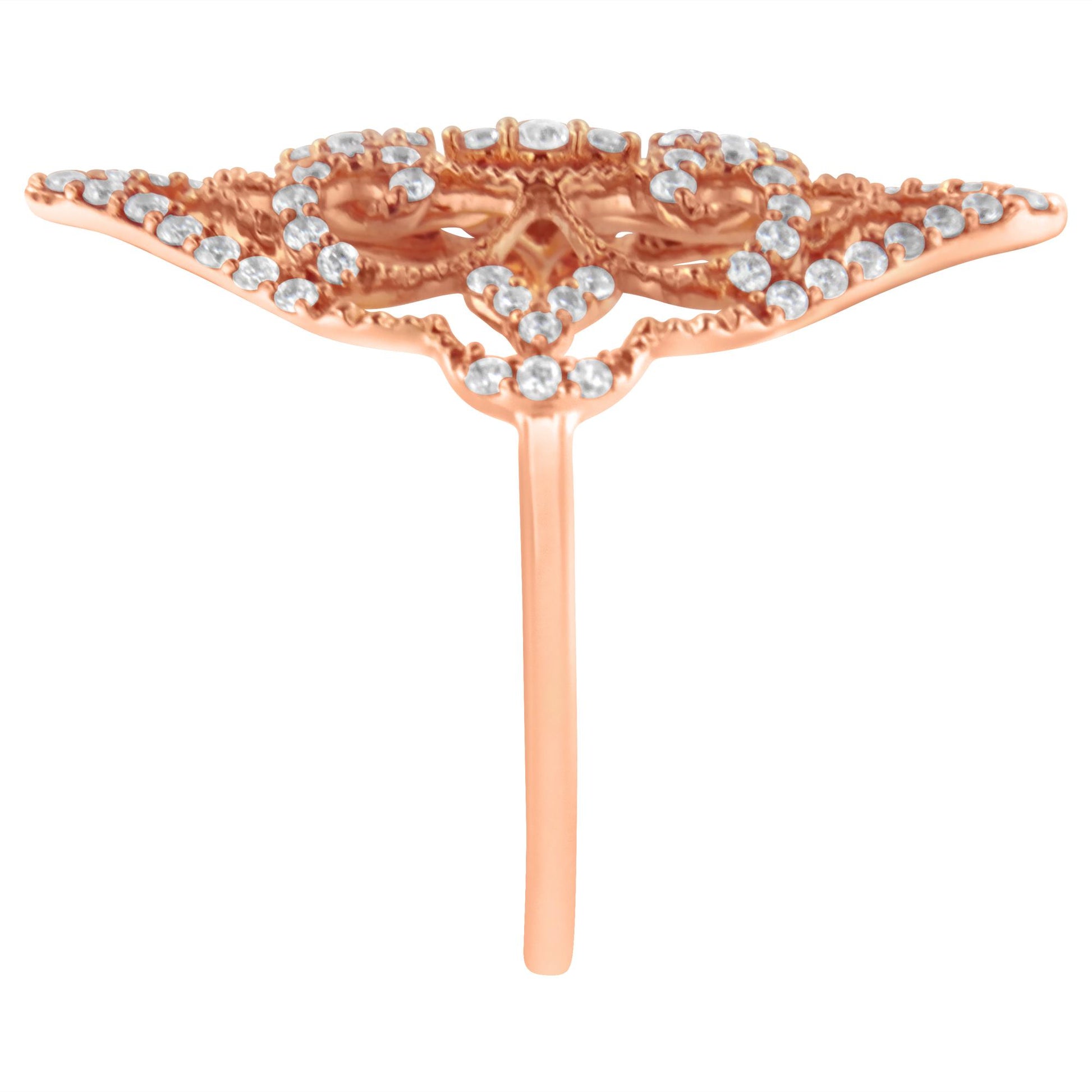 Front view of a rose-colored metal ring with a wide, intricate design adorned with small round white gemstones in prong settings.