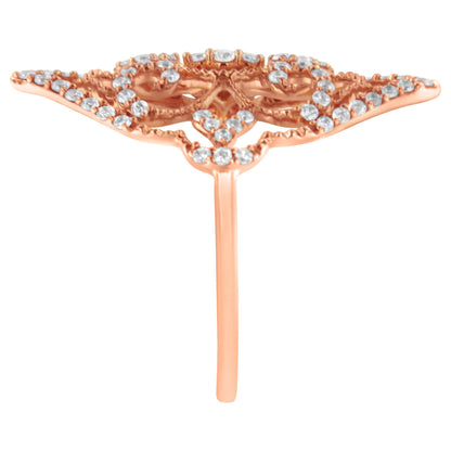 Front view of a rose-colored metal ring with a wide, intricate design adorned with small round white gemstones in prong settings.