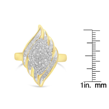 Front-facing angled view of a yellow metal ring with clustered round white gemstones in prong settings at the center, surrounded by rows of white baguette-shaped gemstones in channel settings, shown next to a ruler for size reference.