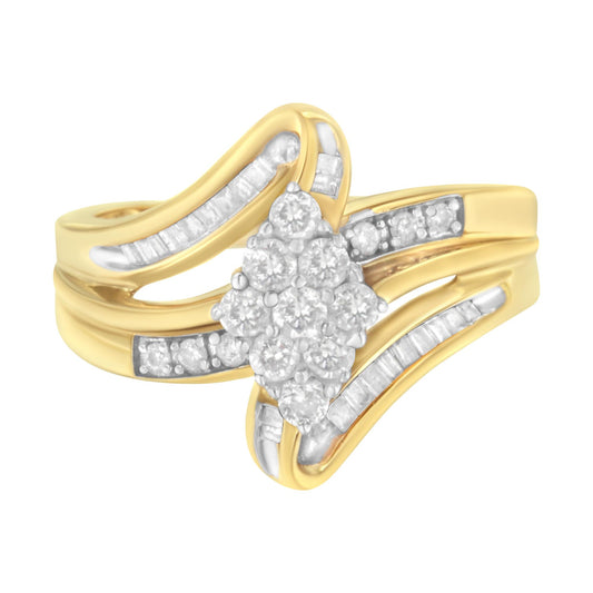 Yellow metal ring with a cluster of round white gemstones in prong settings at the center, flanked by curved rows of channel-set baguette white gemstones, shown from a front angle.