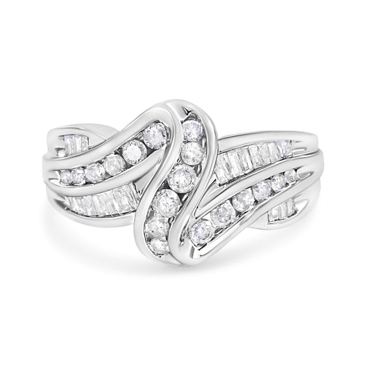 Front view of a white metal ring with curved bands set with channel-set round white gemstones and baguette-shaped white gemstones.
