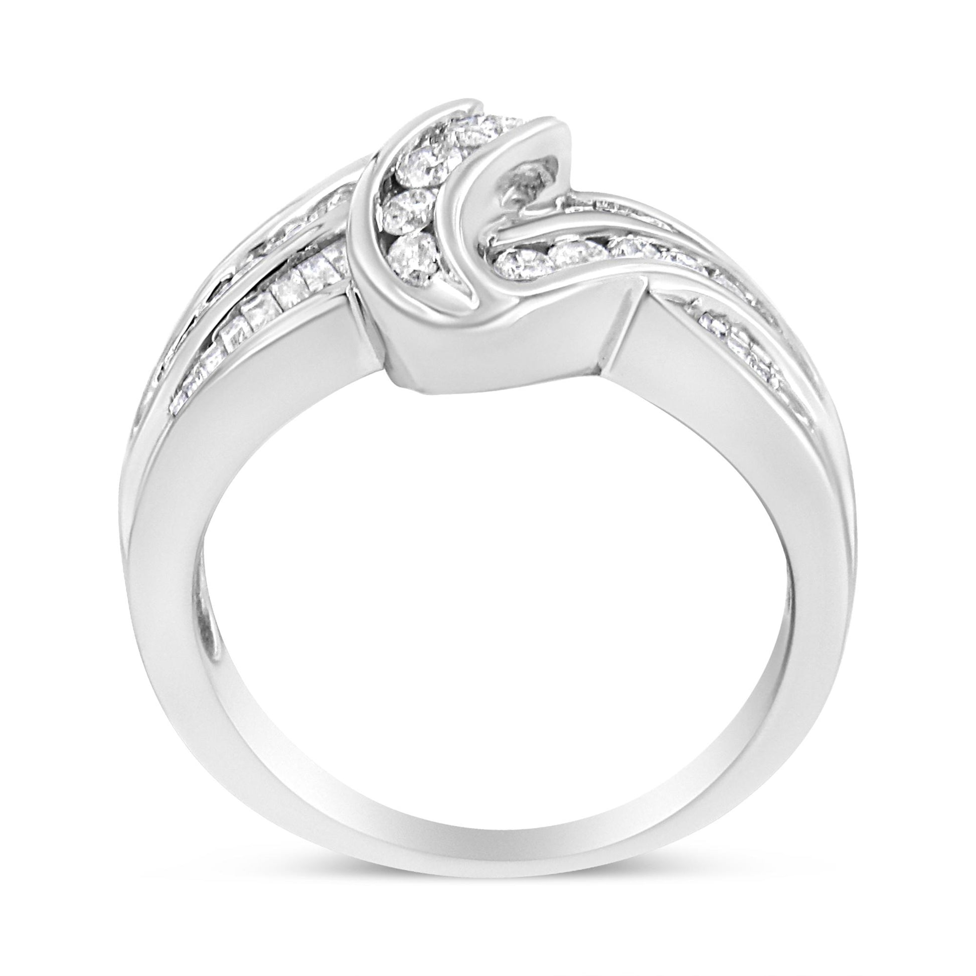 White metal ring with a twisted design, featuring channel-set round and baguette white gemstones, shown from a side angle.