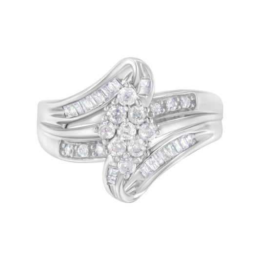 White metal ring with a cluster of round white gemstones in prong settings in the center, flanked by baguette-shaped white gemstones in channel settings along the split shank, shown in a front-facing close-up angle.