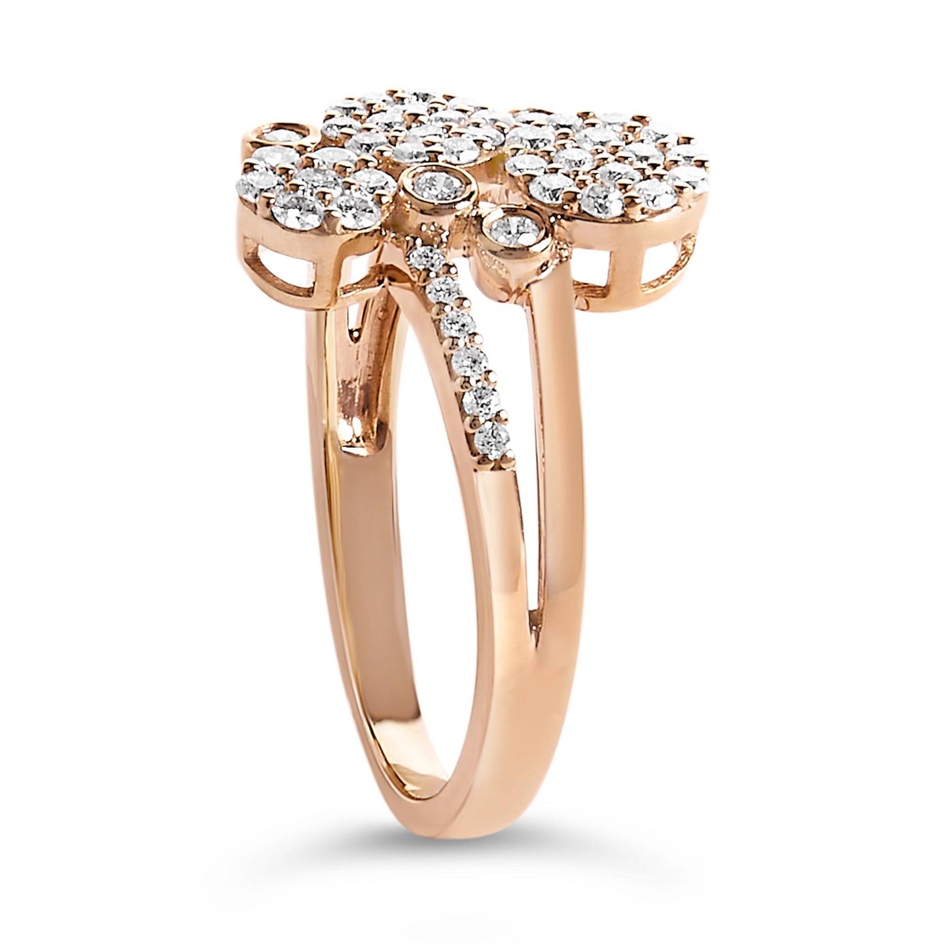 Side angle view of a rose metal ring with multiple clusters of round white gemstones in prong settings on the top and along one band.
