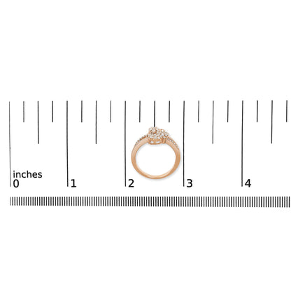 Rose-colored ring with cluster of white gemstones and additional white gemstones set along the band, shown from a side angle on a ruler for size reference.