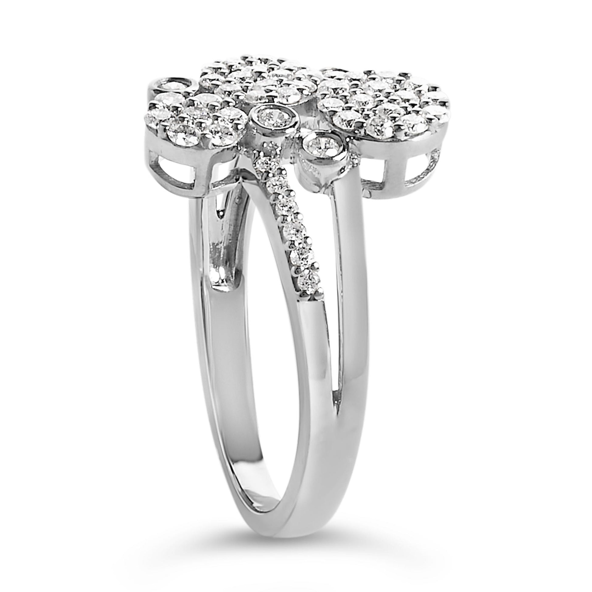 Close-up angled side view of a white metal ring featuring multiple round white gemstones in prong settings clustered on top and along one side of the band.