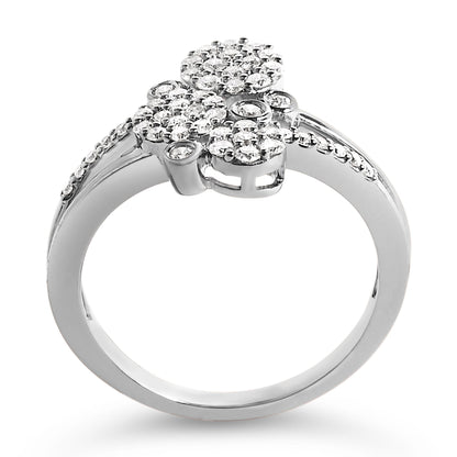 White metal ring with a floral cluster of round white gemstones in prong settings, accented with small round white gemstones along the band, shown in a front angled close-up shot.