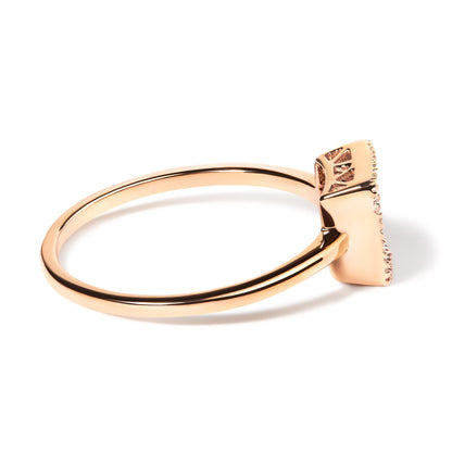 Side angle view of a rose metal ring with a rectangular top featuring multiple small white gemstones in an invisible setting.