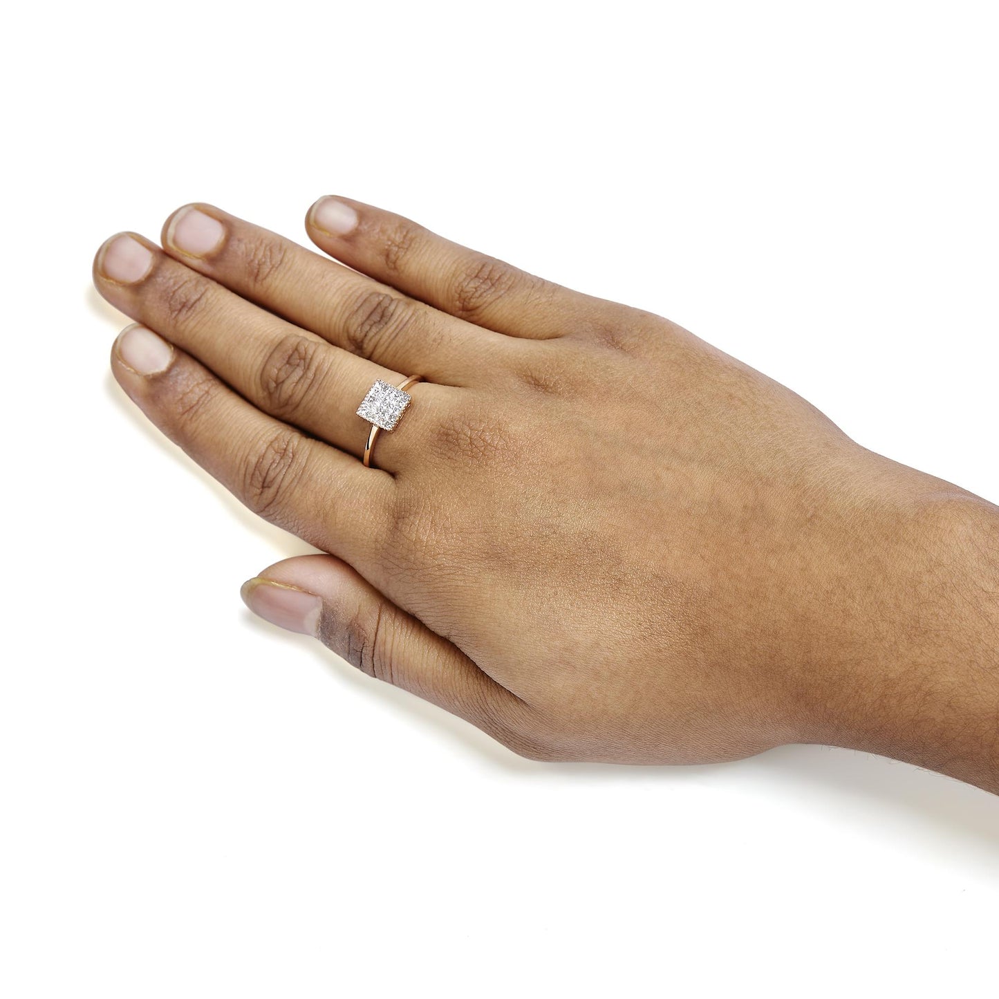 Rose metal ring with a square cluster of white princess-shaped gemstones in an invisible setting, shown on a model's hand from a top angle.