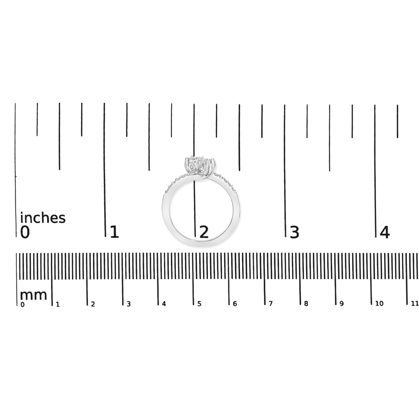 White metal ring with a round center gemstone in miracle setting flanked by two round gemstones, with additional smaller round gemstones along the band in shared prong setting, shown on a scale from a side angle.