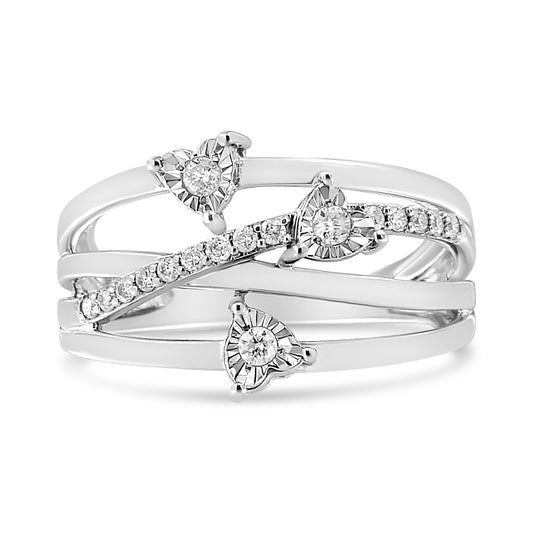 Front angle view of a white ring with three heart-shaped settings each holding a round white gemstone in miracle setting and a diagonal row of round white gemstones in prong setting across the band.