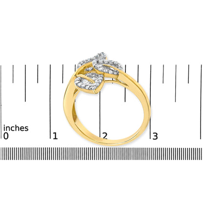 Yellow metal ring with curved design featuring white round and baguette gemstones, shown on a ruler for size reference, top view.