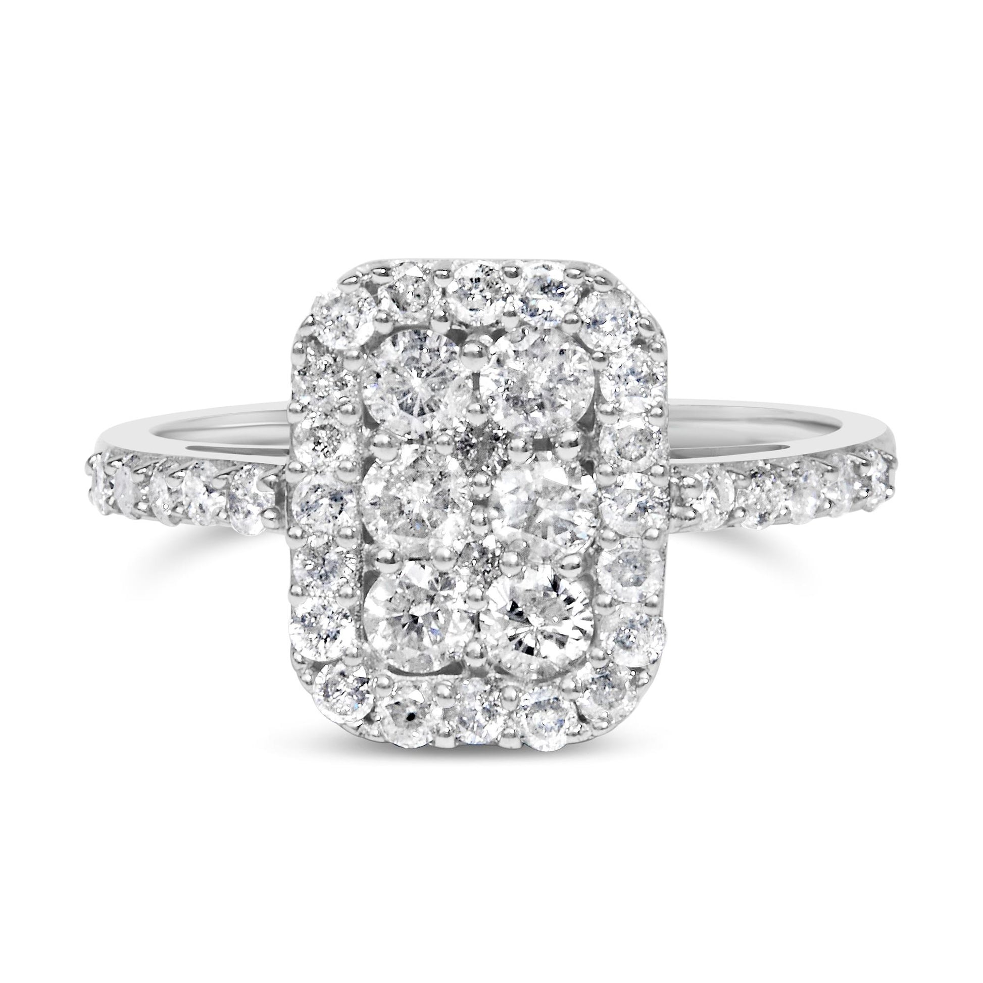 Front-facing close-up of a white metal rectangular ring featuring clustered round white gemstones in prong settings with additional smaller gemstones around the center and along the band.