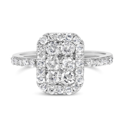 Front-facing close-up of a white metal rectangular ring featuring clustered round white gemstones in prong settings with additional smaller gemstones around the center and along the band.