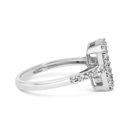 Side view of a white ring featuring a raised rectangular setting with white round gemstones in prong settings along the band and cluster on the top.