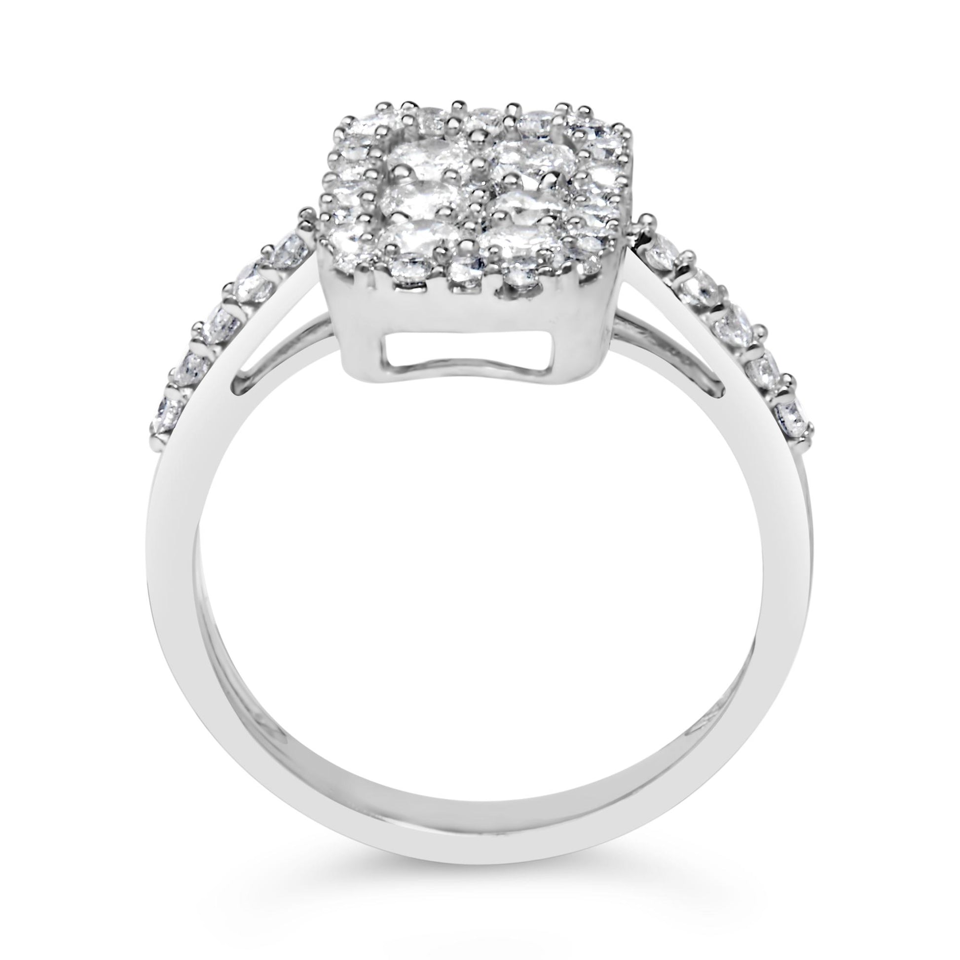 Front-facing close-up of a white metal ring with a square cluster of round white gemstones in prong settings on top and additional round white gemstones set along the shoulders.