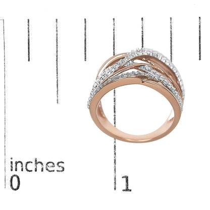 Rose metal ring with multiple overlapping bands, adorned with five white round gemstones in pave setting, shown on a ruler for size reference, angled top view.