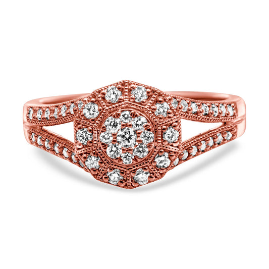 Close-up front view of a rose-colored ring with a hexagonal cluster of white round gemstones in pave setting, featuring additional white round gemstones along the split shank.