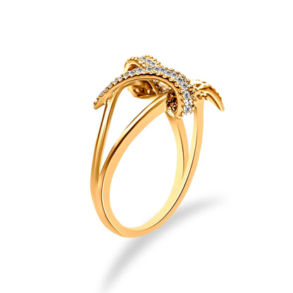 Yellow metal ring with a crisscross design and pavé-set white round gemstones, shown at a slight angle.