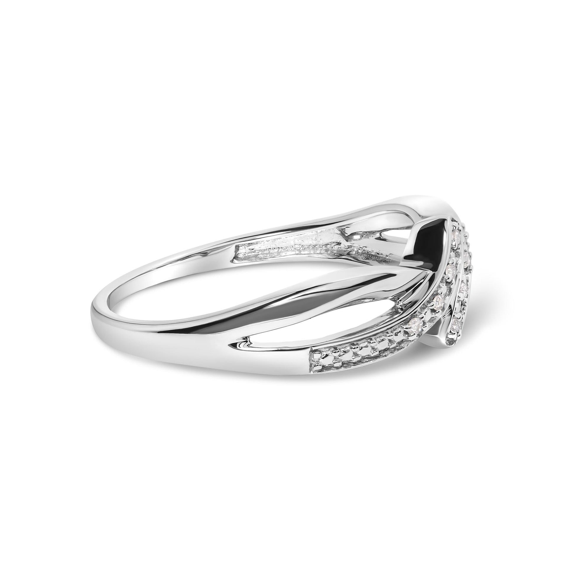 Side angle view of white metal ring with round white gemstones in prong settings along the band.