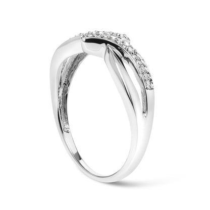 Side angle view of a white metal ring with a crossover design featuring multiple round white gemstones in prong settings on top.