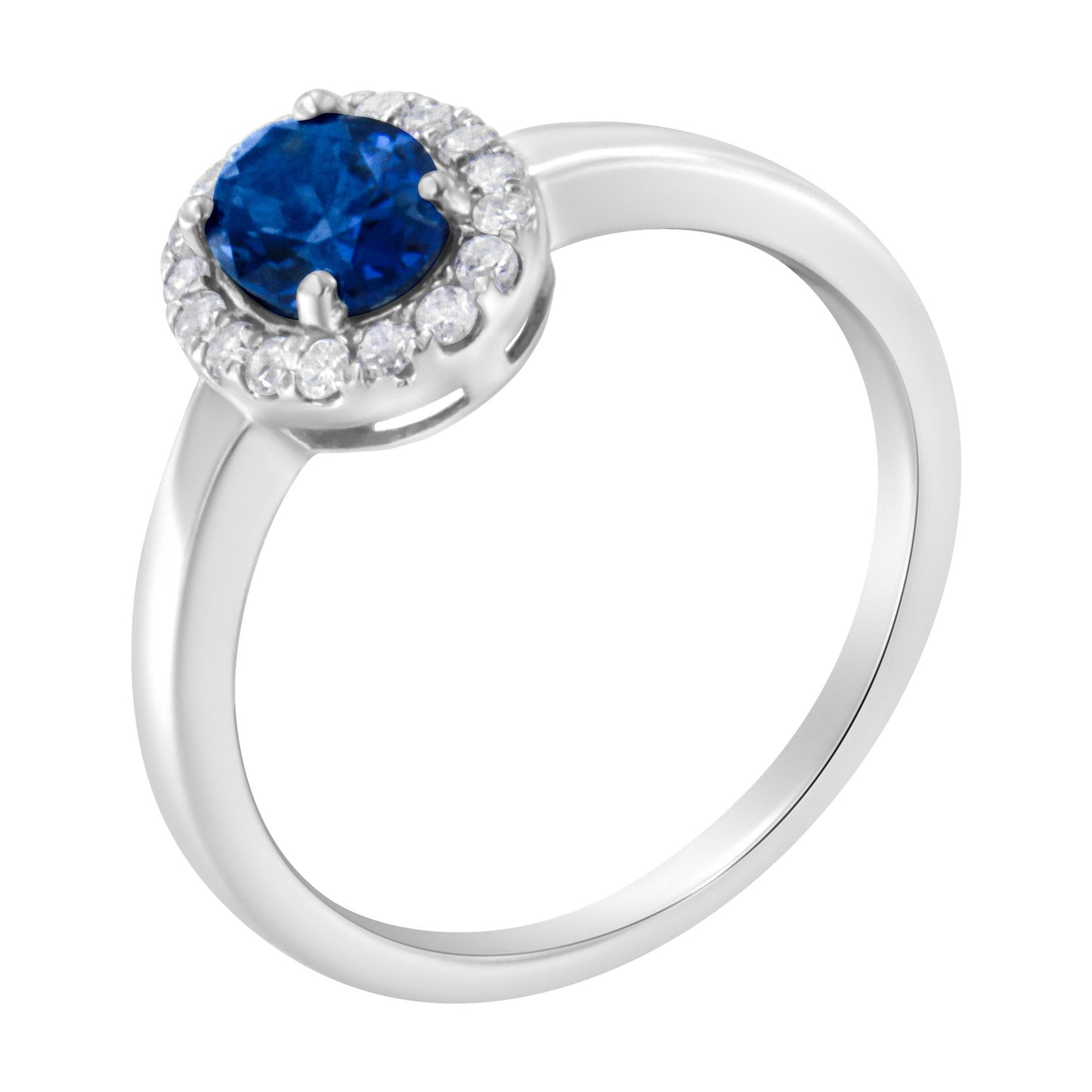 White metal ring with an oval blue gemstone center surrounded by round white gemstones in a prong setting, shown in a tilted close-up angle.