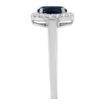 Side view of a white ring featuring a central oval blue gemstone surrounded by a halo of small round white gemstones in prong settings.