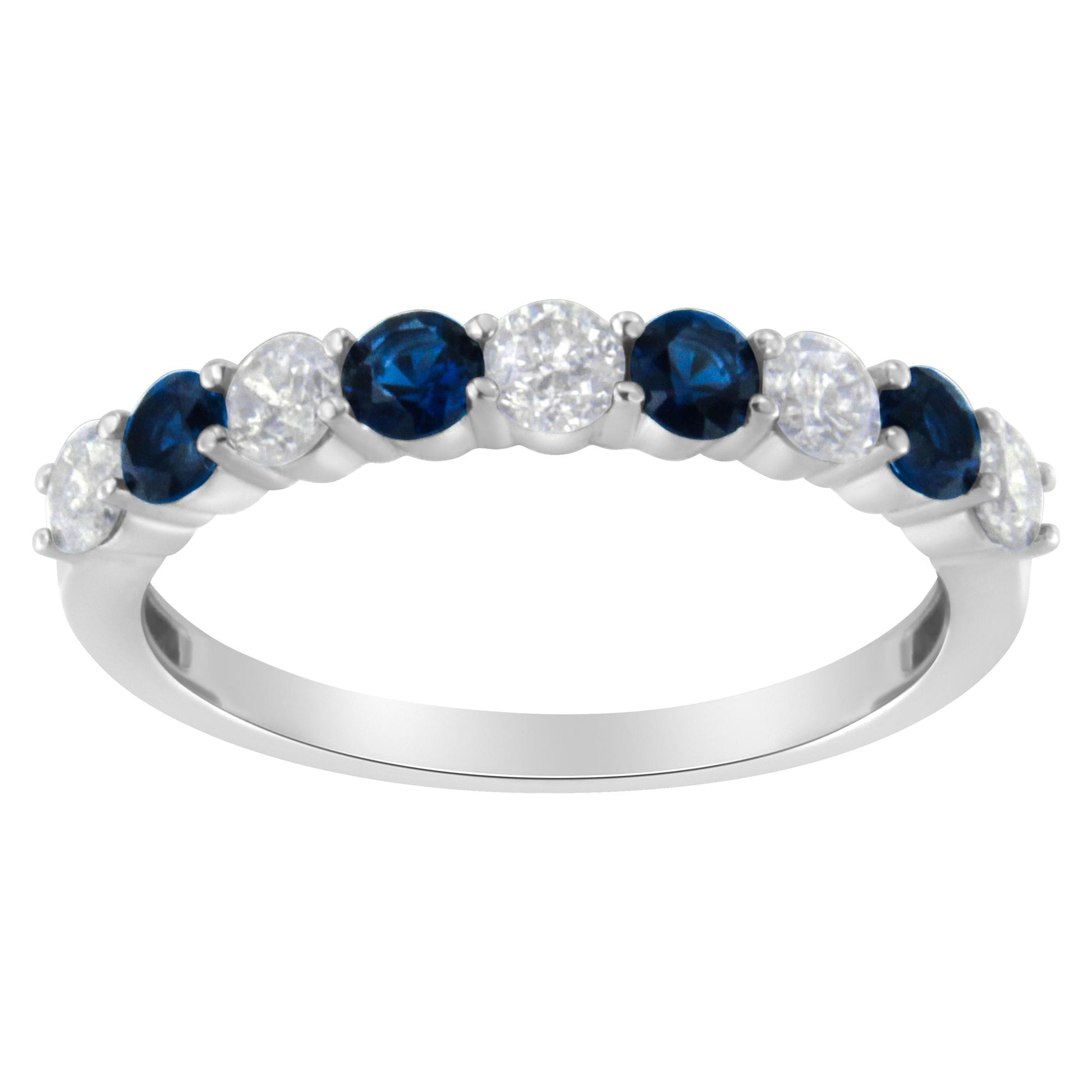Close-up front view of a white metal ring featuring alternating round white gemstones and round blue gemstones in prong settings.