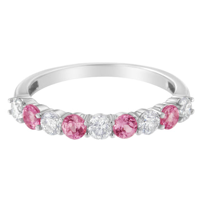 Front angled view of a white metal ring featuring alternating round white gemstones and round pink gemstones in prong settings.