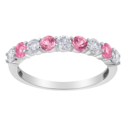 White metal ring with alternating round white and pink gemstones in prong settings, shown from a side angle.