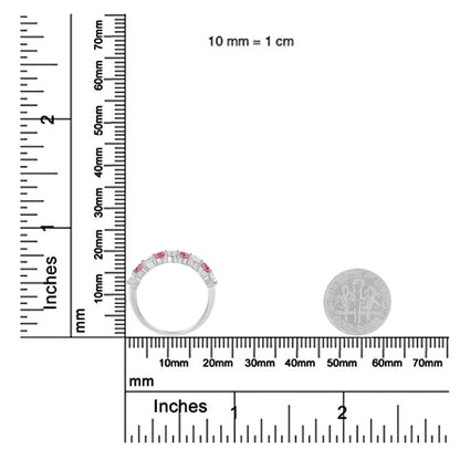 White metal ring with alternating round white and pink gemstones in prong settings, shown from side angle on a ruler and scale for size reference.
