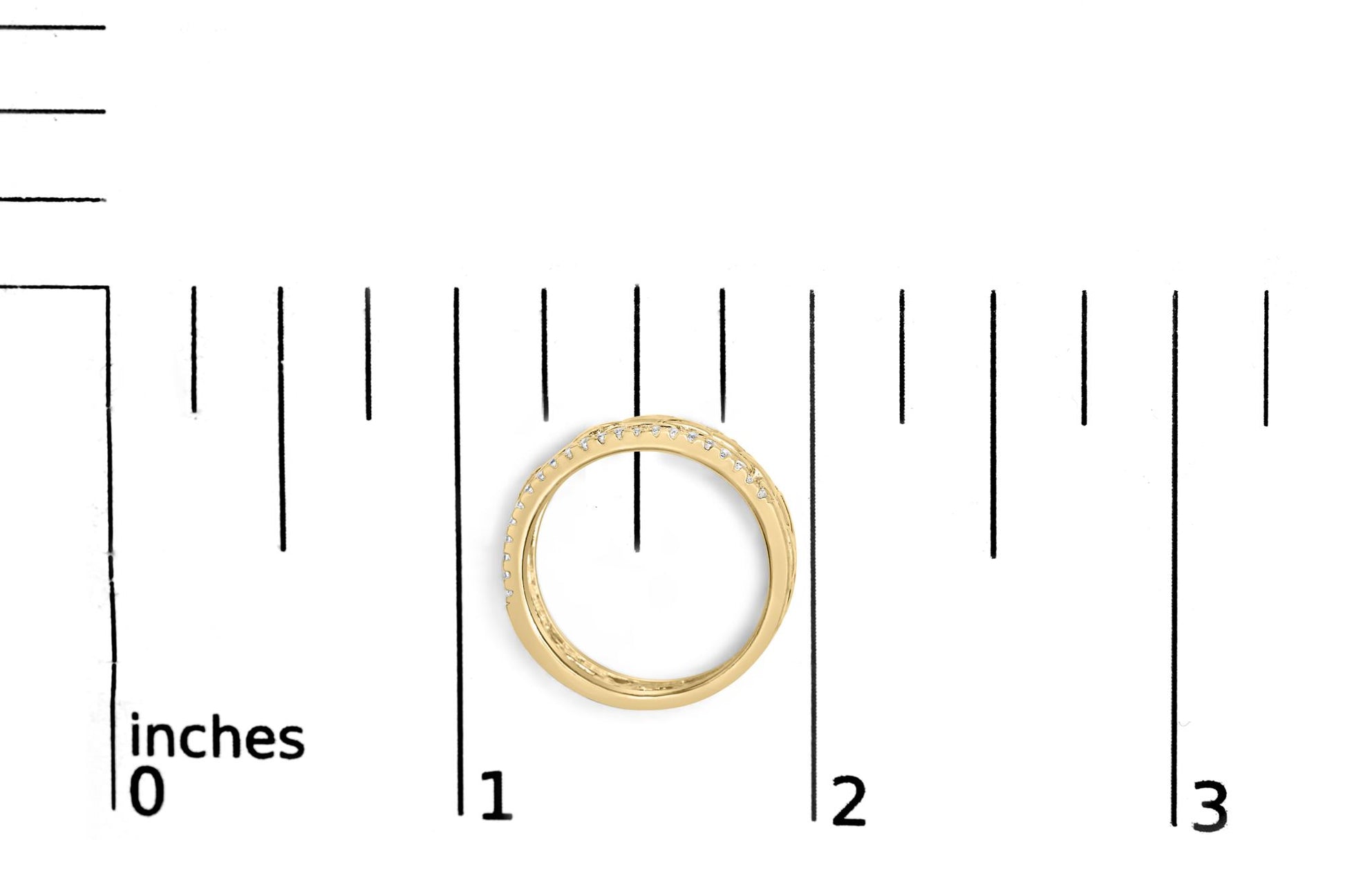 Top-down view of a yellow ring with white round gemstones set in a channel setting, placed on a ruler for size reference.