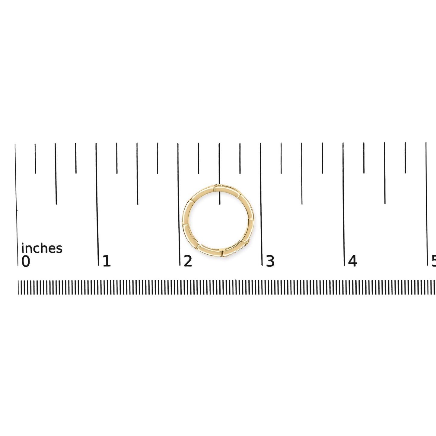 Top-down view of a yellow metal ring with round white gemstones set in a channel, placed on a ruler for size reference.
