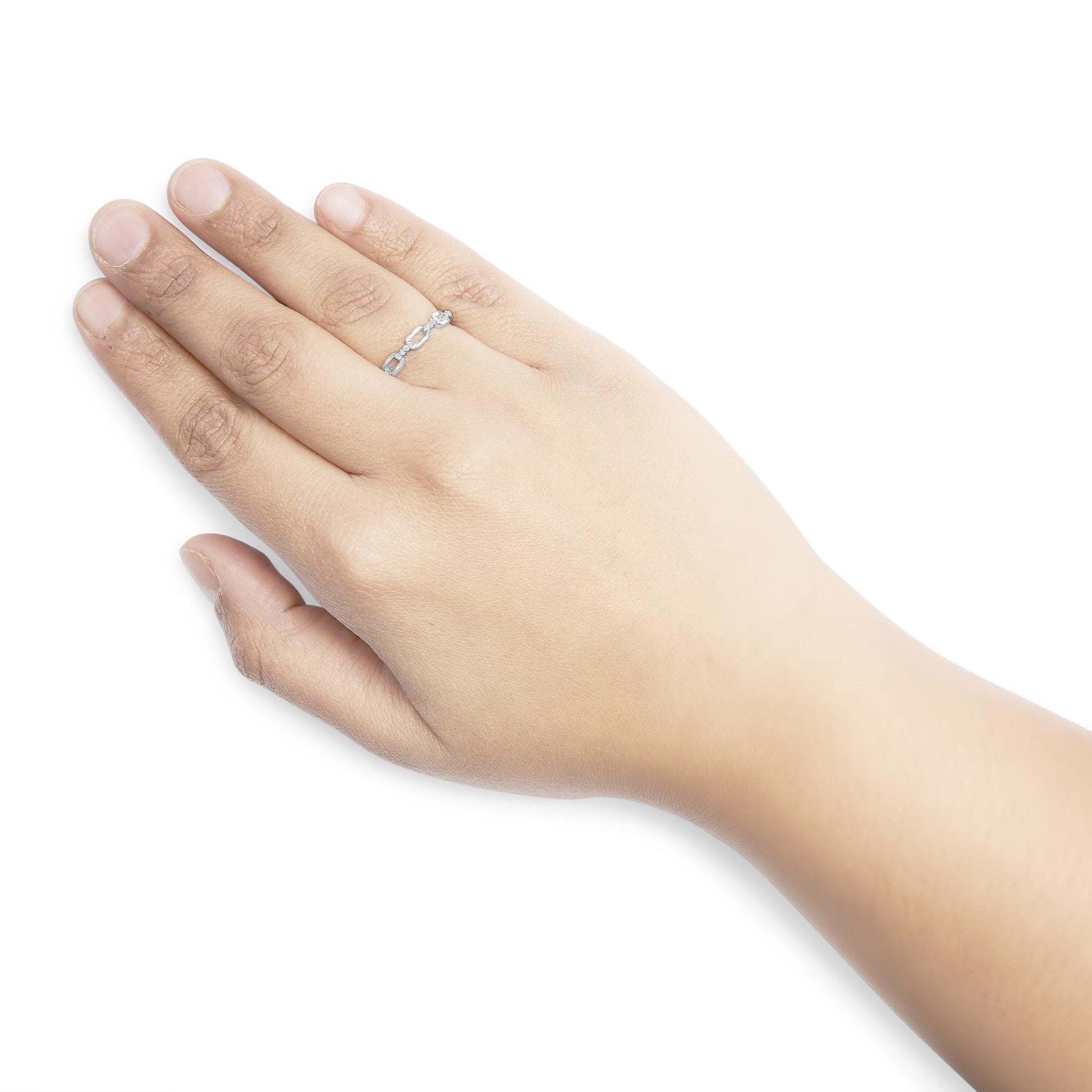 White metal ring with round white gemstones in prong settings, worn on a model's hand, shown from top angle.