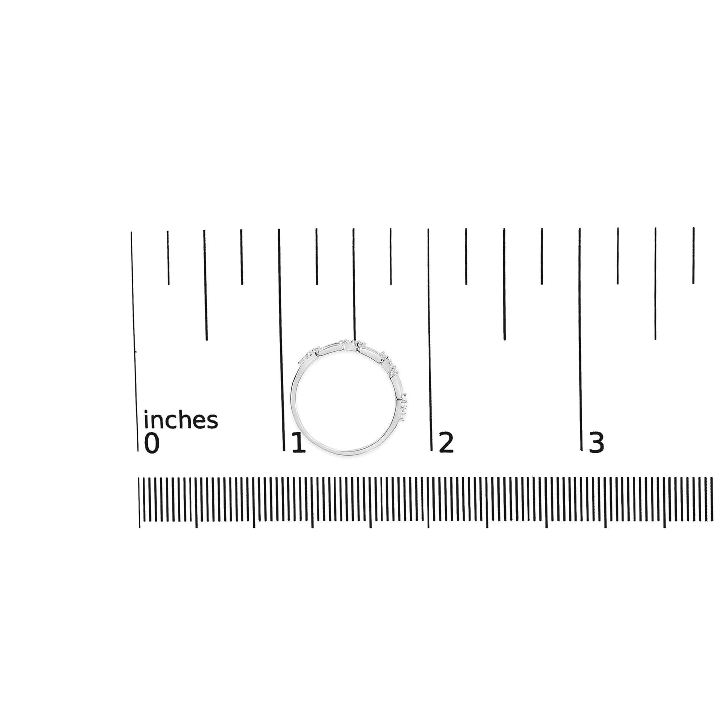 Top-down view of a white metal ring with round white gemstones in prong settings, placed on a ruler for size reference.
