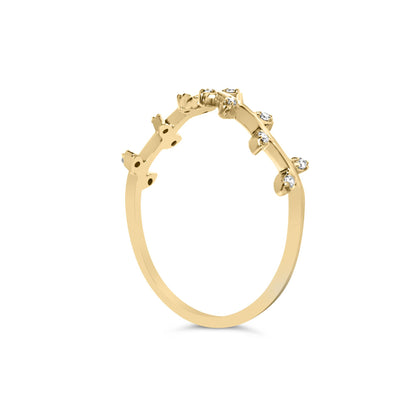 Yellow metal ring with multiple small white round gemstones in prong settings, shown from a side angle.