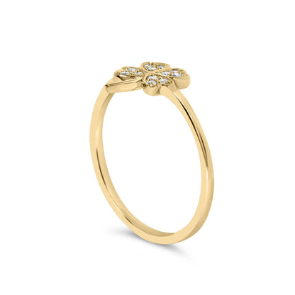 Yellow metal ring with a flower-shaped top set with round white gemstones, shown from a side angle.